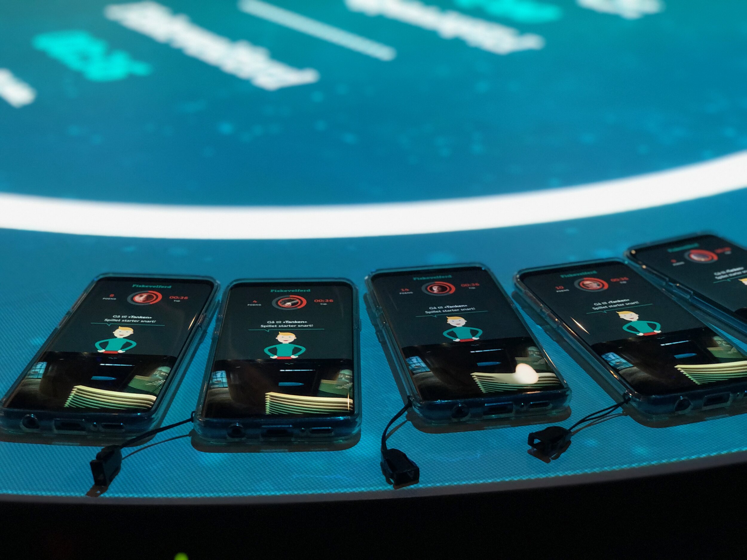 Several phones lying on a screen with a countdown and questions on them.